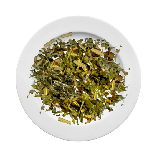 Loose-leaf Jaroma Tea Body Balance blend displayed on a white plate. A vibrant mix of soursop leaves, papaya leaf, lemongrass, ginger, and blue mallow—light green with pops of herbal texture. Designed to support cleansing and natural balance.