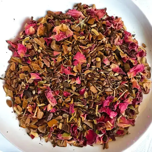 Loose-leaf blend of Jaroma Detox Bliss Colon Tea, featuring a blend of rose petals and herbs. The mix includes vibrant pink rose petals alongside a variety of organic herbs, offering a fragrant and health-boosting infusion aimed at supporting digestion and detoxification.