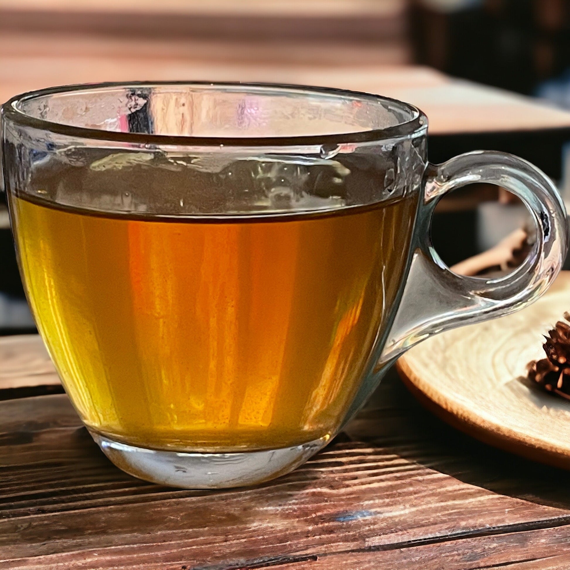 Jaroma freshly brewed colon cleanse tea in a glass cup standing on the rustic wooden table