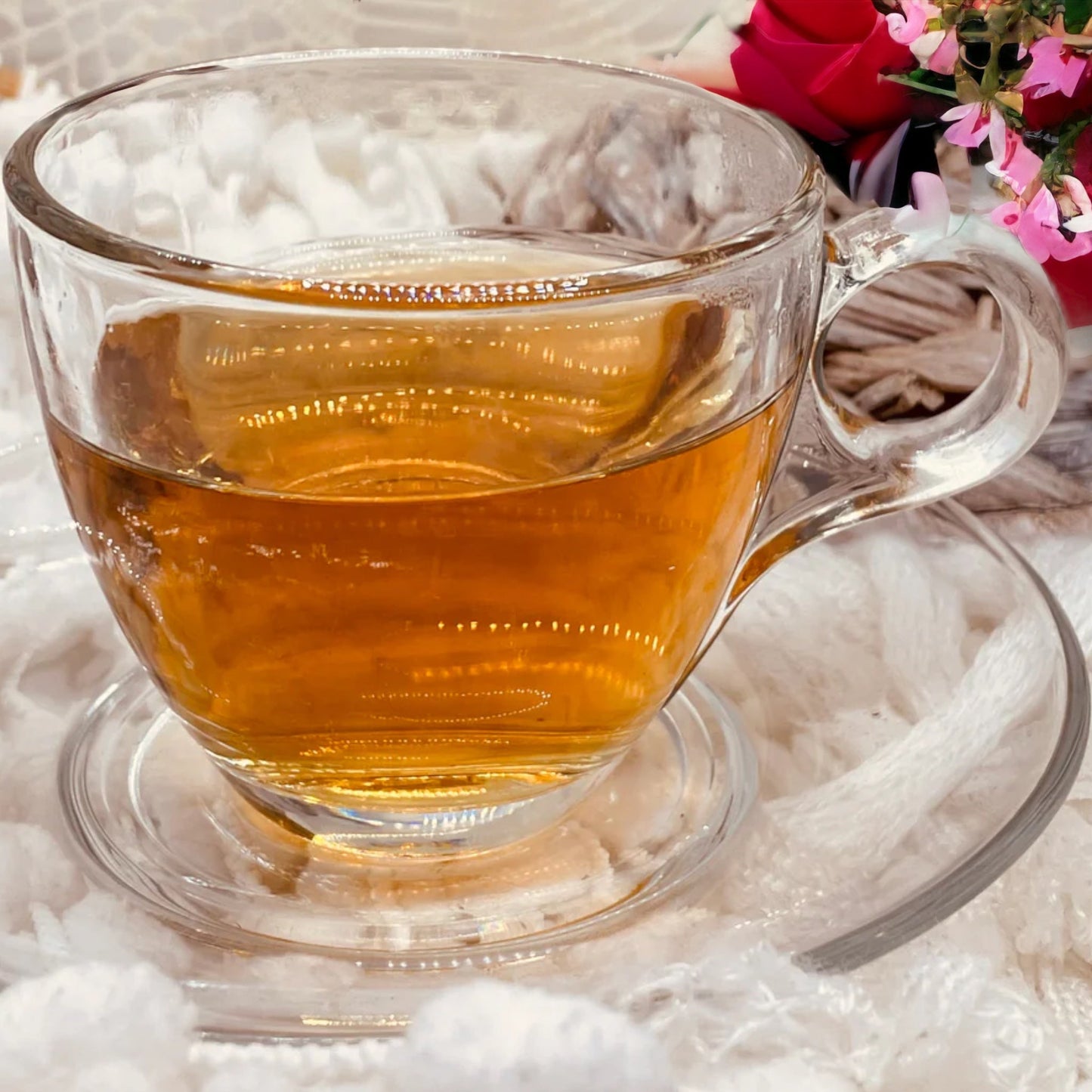 A freshly brewed cup of Happy Morning tea is in a glass cup of beautiful of gold amber ted colour.