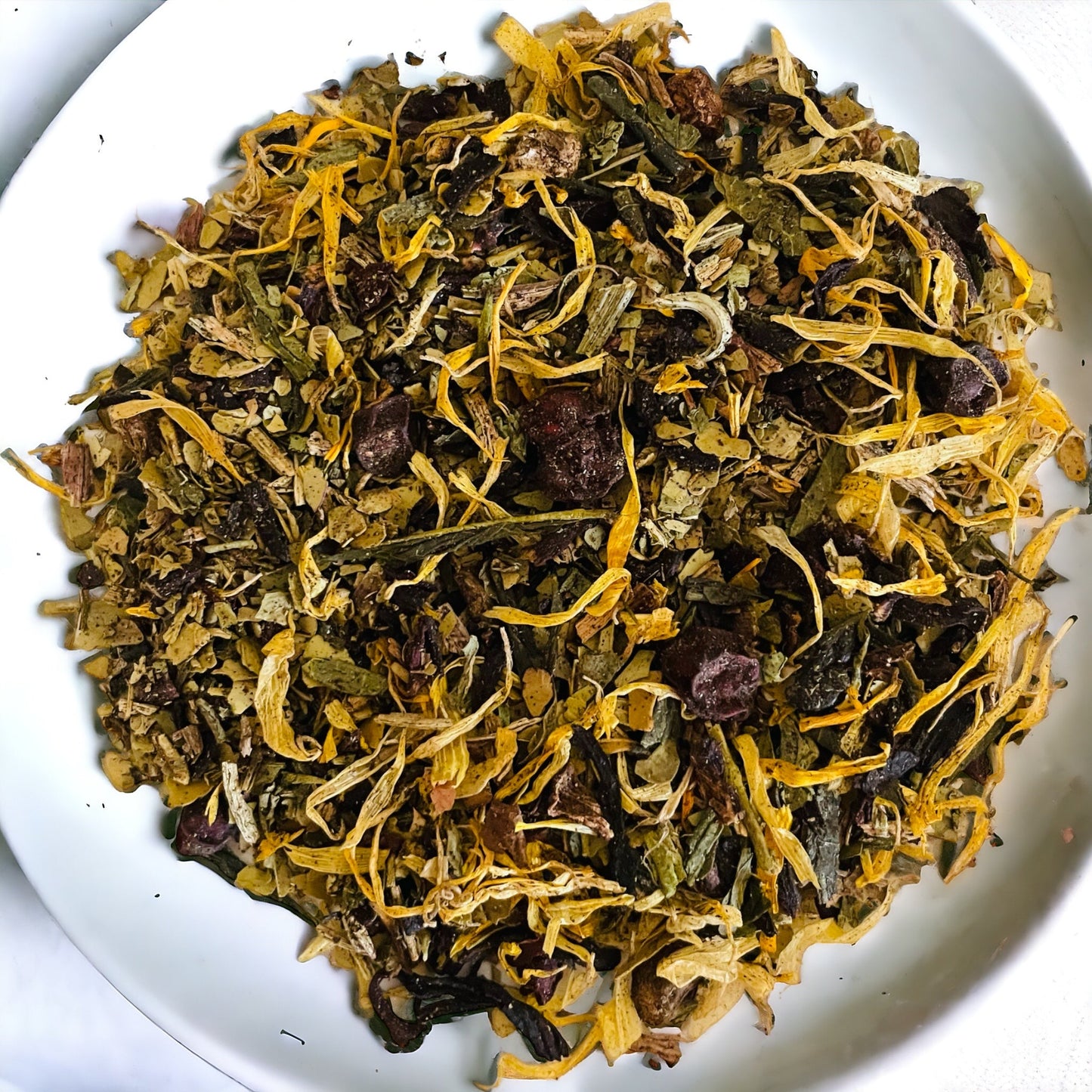 Organic dried yellow and green slimming tea herbs on a whiter plate
